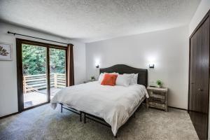 西黄石Geyser Getaway的一间卧室配有带白色床单和橙色枕头的床。