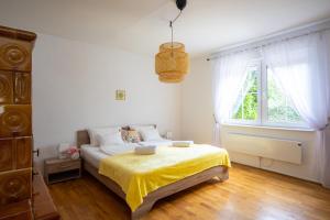 巴拉顿阿卡拉提亚Oliva 8 fős Balatoni Nyaraló的一间卧室配有一张带黄色床单的床和一扇窗户。
