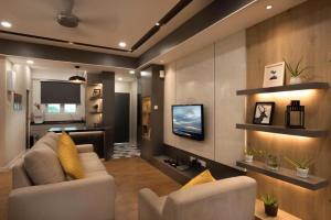 瓜埠Designer Suite Apartment Seaview 10pax Families Suite的带沙发和电视的客厅