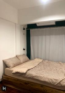 合艾BAAN64 Hostel的一间卧室配有一张带窗帘的床和一张四柱床