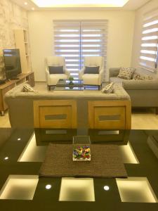 An NakhlahElite Residence - Furnished Apartments的客厅配有沙发和桌子