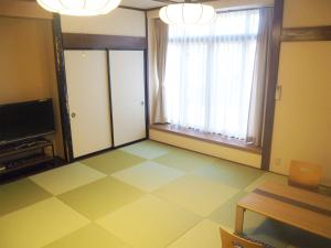 高山高山日式旅馆的客厅设有大窗户 和瓷砖地板。