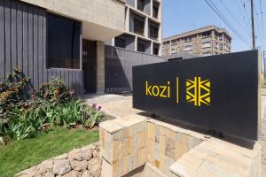 内罗毕Kozi Suites Nairobi Airport的建筑前的牛 ⁇ 标志
