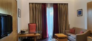 新德里乌姆劳度假村的带沙发的客厅和带窗帘的窗户