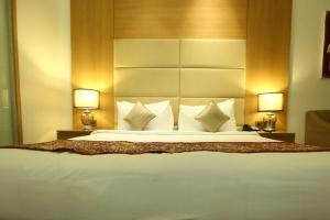 新德里乌姆劳度假村的一张大床,位于酒店带两盏灯的房间