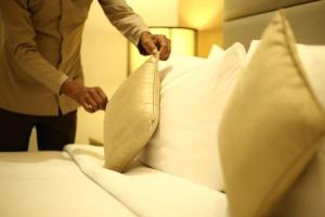 新德里乌姆劳度假村的男人把枕头放在床上