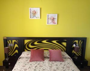 德尼亚El Respiro verde的黄色卧室配有带2个粉红色枕头的床