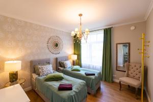 凯尔德拉Tiismani Villa的一间卧室配有两张床、一张沙发和一把椅子