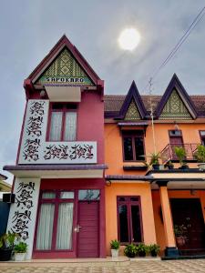 不拉士打宜Sapo Karo Rest House的红色门的多彩房子