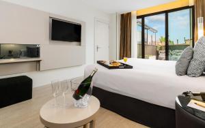 巴塞罗那Grums Hotel & Spa的酒店客房,配有一张床和一瓶香槟