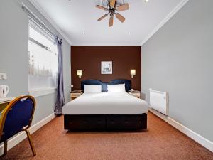 格林福德OYO Bostons Manor Hotel的一间卧室设有一张大床和一个窗户。
