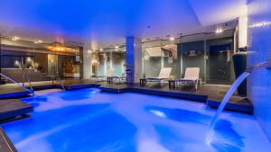巴塞罗那Grums Hotel & Spa的一座配有桌椅的酒店游泳池