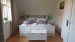 青斯特Haus Sonnenwind的客房内的一张带两个枕头的白色床