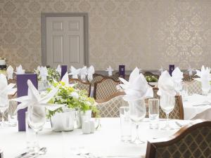 本布里奇The Birdham At Bembridge的用餐室配有白色的桌椅和鲜花