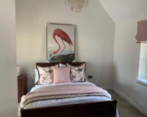 康格尔顿Church View Cottage, Drift House Holiday Cottages的一间卧室配有一张带火烈鸟照片的床