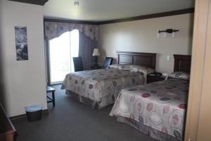 圣安娜德蒙Manoir sur Mer的酒店客房设有两张床和窗户。