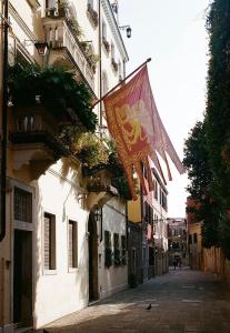 威尼斯Ca' del Pittor Apartments的悬挂在建筑物一边的旗帜