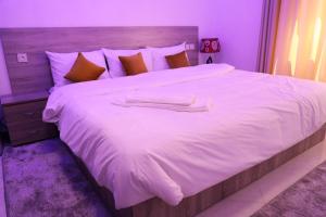 阿尤恩HOTEL NOON的一张白色的大床,带两条毛巾