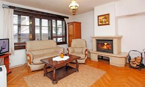 洛维奇Family Hotel Varosha 2003的客厅配有两把椅子和壁炉
