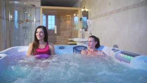 StrzyżówDwór Maria Antonina的两个女人坐在热水浴缸里