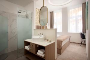 布达佩斯Mera Hotel的一间带水槽、床和镜子的浴室