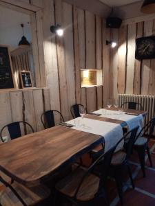 韦尔科尔地区格雷斯Auberge Buissonniere的配有木墙和椅子的客房内的桌子