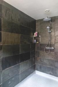 滕伯里The Costrel的浴室设有黑色瓷砖淋浴。