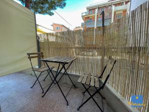 佩斯卡拉Florian Home的阳台设有两把椅子和一张桌子,阳台设有围栏