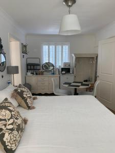 利明顿Harford en-suite Rooms的卧室配有一张白色大床和一张书桌