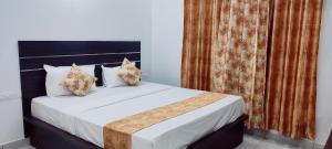迈索尔Suvarna Elite - Premium Apartment Hotel的一间卧室配有带白色床单和枕头的床。