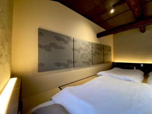 名古屋Kikunoya - Vacation STAY 83152的卧室配有两张床,墙上挂有一张海报