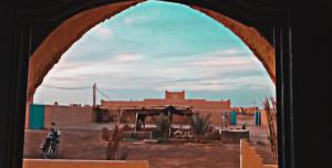 梅尔祖卡Gite GAMRA的享有沙漠美景,设有一座建筑和一辆摩托车