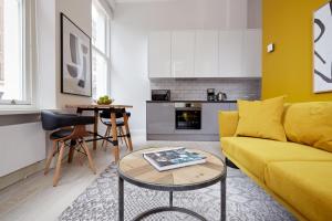 伦敦2VH Virginia House, 31 Bloomsbury Way by City Living London的客厅配有黄色的沙发和桌子