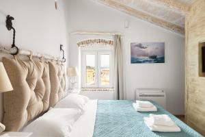 科孚镇Sky Loft Corfu Old Town Apartments的白色卧室配有一张大床和两条毛巾