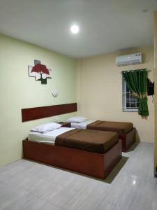 杜迈Wisma Cemara Dumai的一间卧室配有两张床和电视。