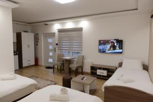 兹雷尼亚宁Kovač Residence的客房设有两张床和一张带电视的桌子。