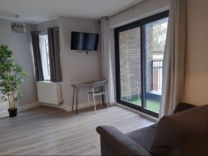 CranfordApartments Heathrow - Hounslow的带沙发、桌子和窗户的客厅