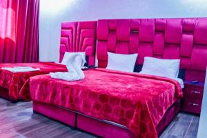 胡里卜盖HOTEL BORJ EL ARAB的一间卧室设有两张带红色大床头板的床