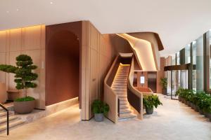 伦敦伦敦泛太平洋酒店的一座种植了盆栽植物的建筑中的螺旋楼梯