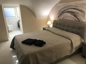卡塔尼亚Donizetti House的一间卧室配有一张带两张黑色毛巾的床
