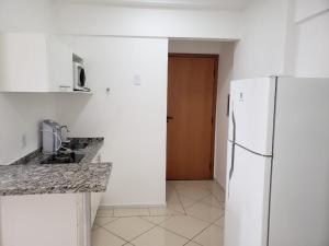 圣卡洛斯Spot Residence São Carlos 700m da USP的一间白色的厨房,配有冰箱和门