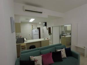 亚喀巴Rental unit in RAHA village compound, special view的一间带蓝色沙发的客厅和一间厨房
