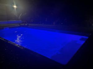 圣若瑟L'escapade créole Jacuzzi Privatif Bungalow Vanille的夜晚的蓝色游泳池