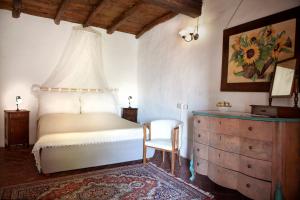 CasalzuignoAntico Borgo Sanda Lago Maggiore的一间卧室配有一张床、一把椅子和一个梳妆台