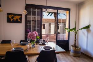 拉拉古纳La Laguna Treasure: exclusiveness prime location的用餐室配有带玻璃杯和鲜花的桌子