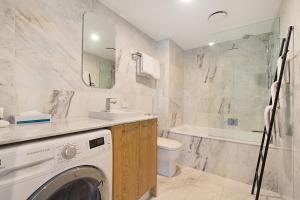 布里斯班杰甫逊公寓及酒店的浴室配有洗衣机、水槽和洗衣机。
