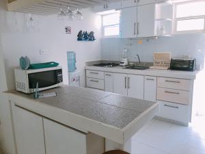 圣安德烈斯Sitio exclusivo y tranquilo的厨房配有白色橱柜和带微波炉的台面。
