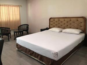 Sedati塞纳3酒店的一间卧室配有一张大床、两把椅子和一扇窗户