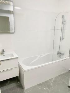 谢西Modern Apartment Disneyland Paris的白色的浴室设有浴缸和水槽。