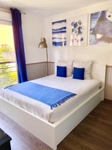 谢西Modern Apartment Disneyland Paris的卧室内的白色床和蓝色枕头
